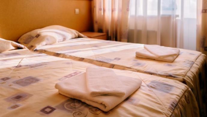 Кровать в номере стандарт с видом на море в гостинице Золотая Пальма в Сочи